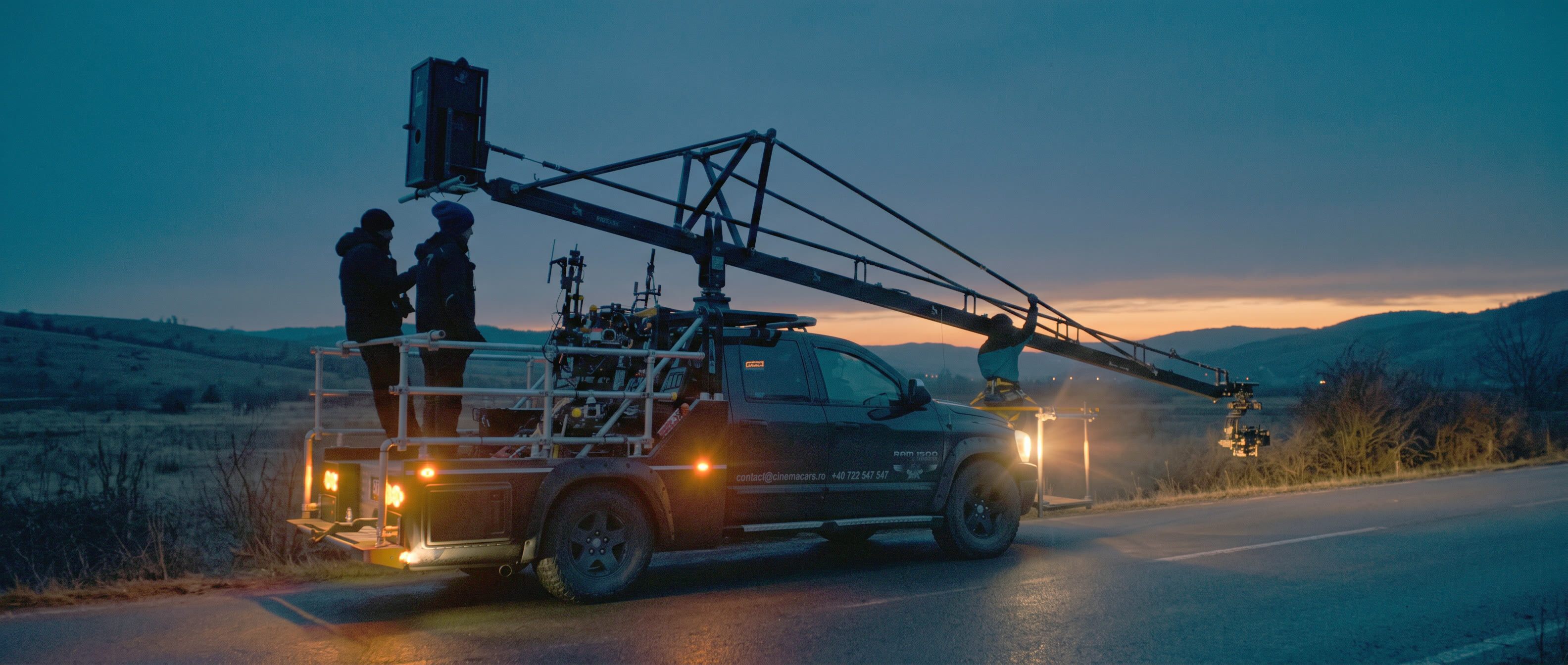 A Cinema Cars Dodge Ram with a camera crane at dusk in the mountains